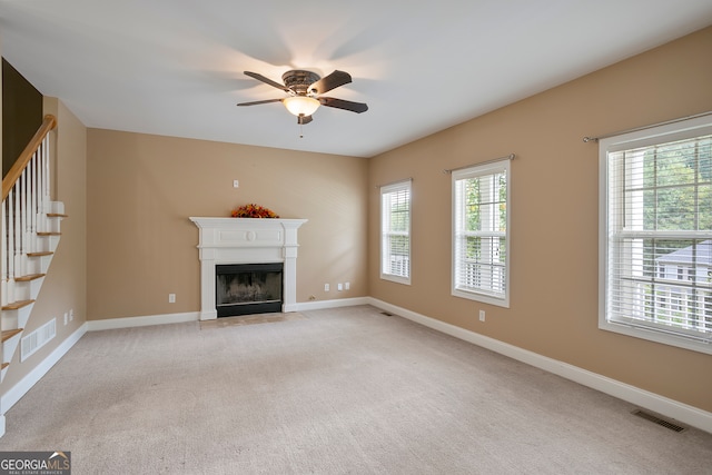 unfurnished living room featuring ceiling fan and carpet flooring