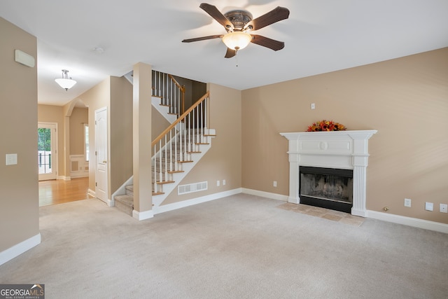 unfurnished living room with light colored carpet and ceiling fan