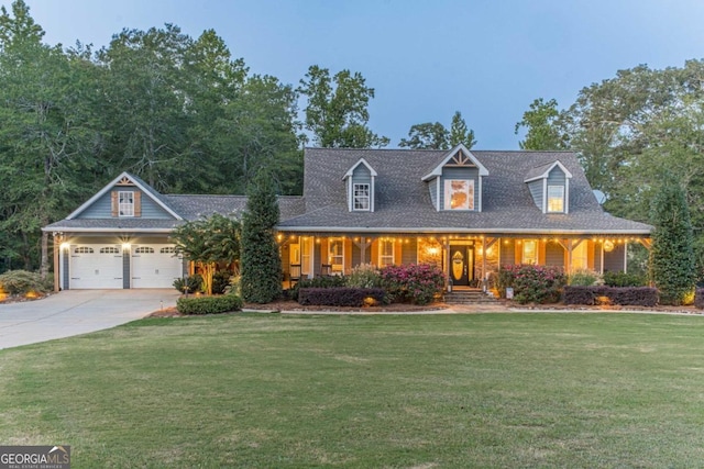 view of front of house with a yard, a garage, and covered porch