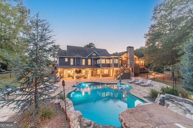 pool at dusk with a patio