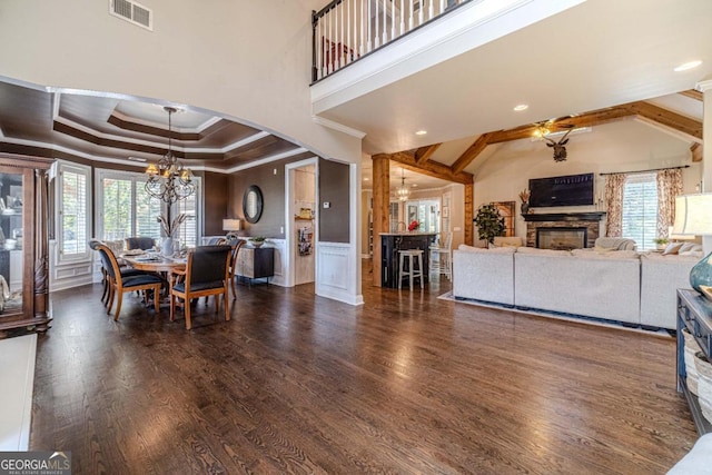 dining space featuring a fireplace, dark hardwood / wood-style flooring, a chandelier, and a wealth of natural light