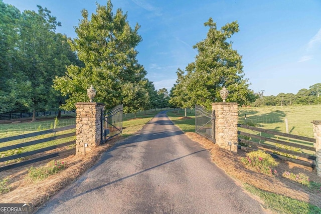 view of gate featuring a yard and a rural view