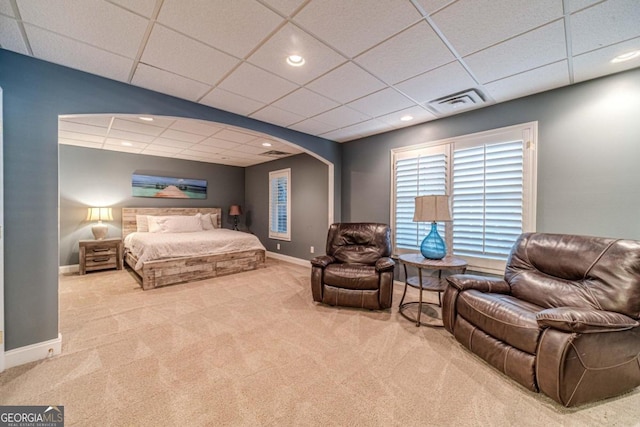 bedroom featuring a drop ceiling and carpet floors