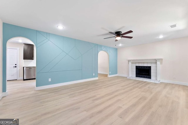 unfurnished living room featuring a fireplace, light hardwood / wood-style flooring, and ceiling fan