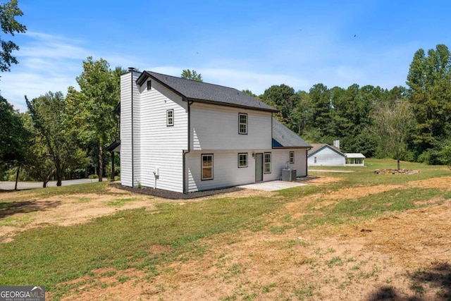 back of house featuring central AC, a yard, and a patio area