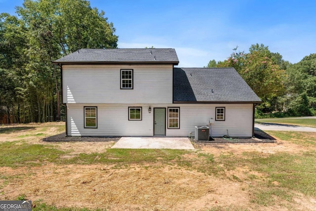 back of property with cooling unit, a lawn, and a patio area