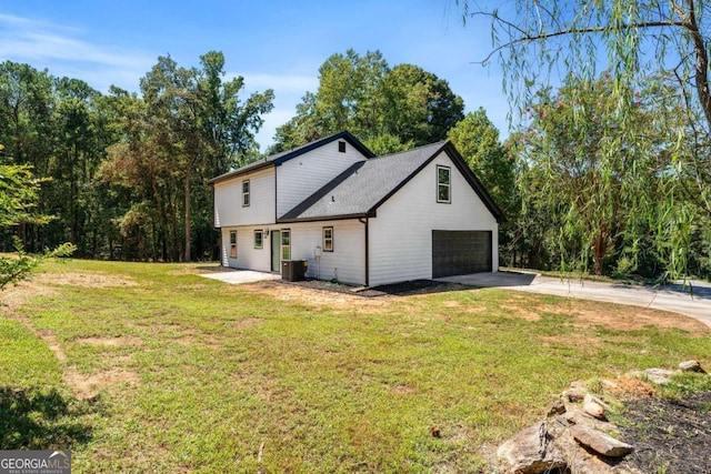 view of property exterior featuring a yard, a garage, and central AC unit