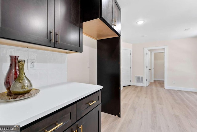 kitchen with decorative backsplash and light hardwood / wood-style floors