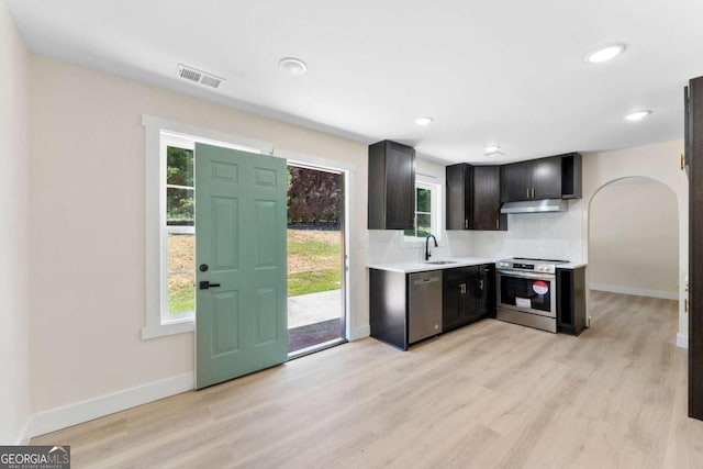 kitchen with light hardwood / wood-style flooring, backsplash, stainless steel appliances, and sink