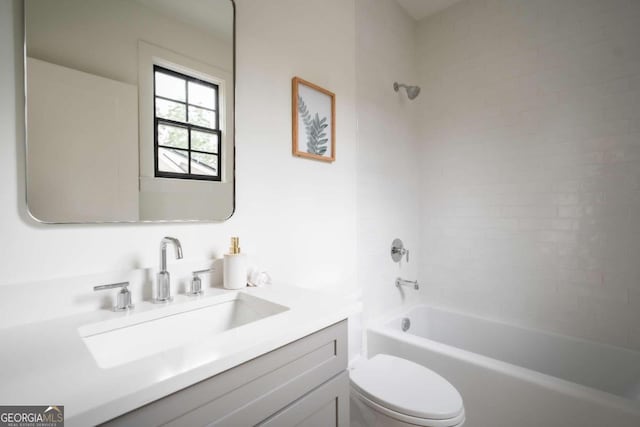 full bathroom featuring tiled shower / bath, vanity, and toilet