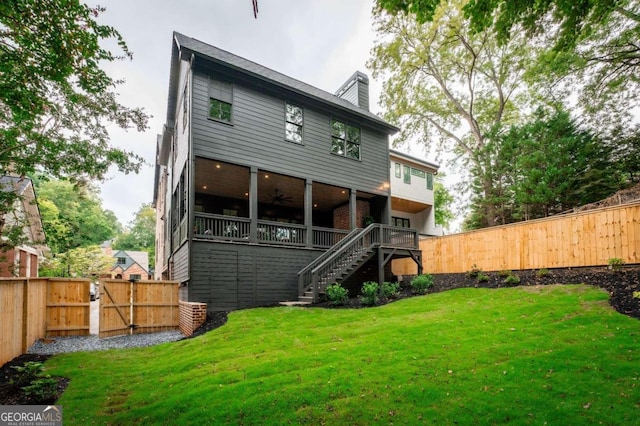 rear view of house featuring a yard and ceiling fan