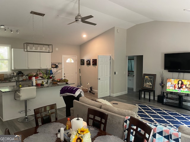 living room with vaulted ceiling, dark hardwood / wood-style flooring, and ceiling fan