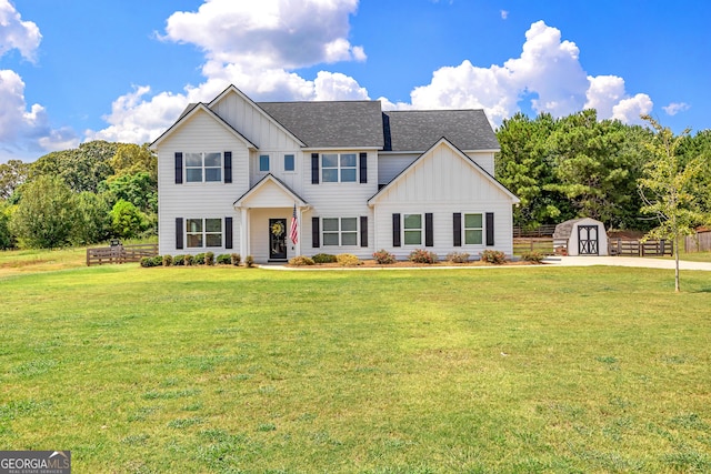 321 Brown Station Dr, Williamson, GA 30292 - view of front of house featuring a storage shed, board and batten siding, an outbuilding, a front lawn, and roof with shingles