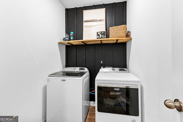 clothes washing area featuring washer and clothes dryer and wood-type flooring