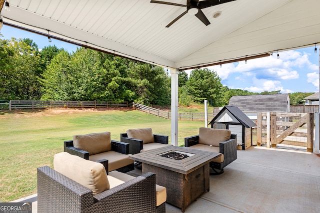 view of patio / terrace with ceiling fan, an outdoor living space with a fire pit, and a storage shed