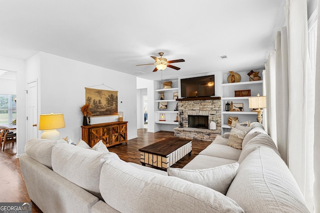 321 Brown Station Dr, Williamson, GA 30292 - living room featuring visible vents, built in shelves, a stone fireplace, ceiling fan, and dark wood-style floors