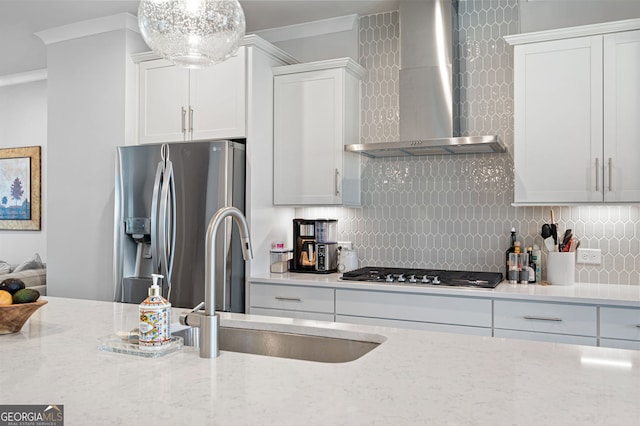 kitchen featuring light stone counters, sink, wall chimney exhaust hood, appliances with stainless steel finishes, and crown molding