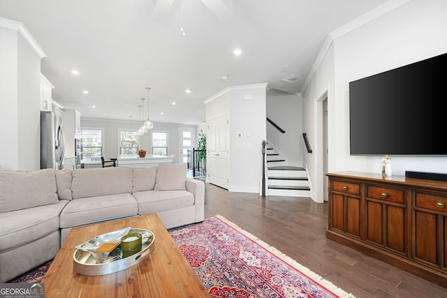 living room with ceiling fan, ornamental molding, and dark wood-type flooring