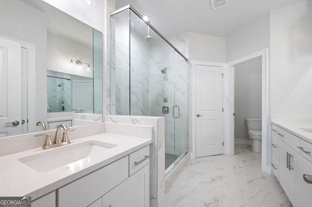 bathroom with vanity, toilet, and a shower with door