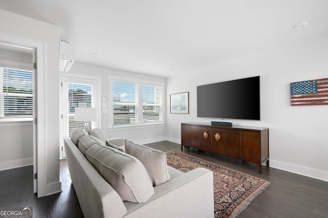 living room featuring dark wood-type flooring and a wall unit AC