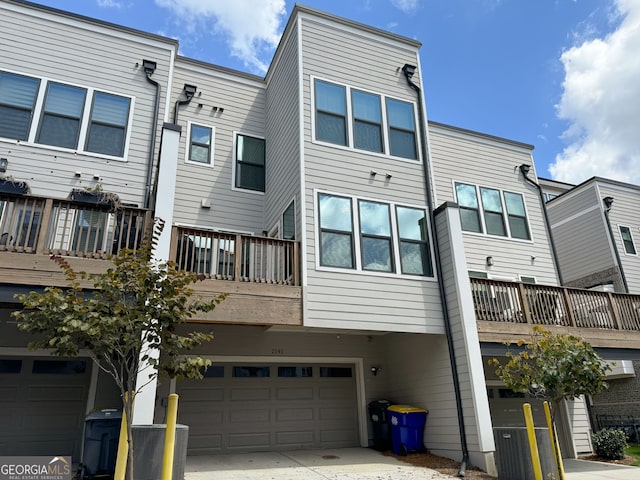 back of property featuring a balcony, a garage, and central AC