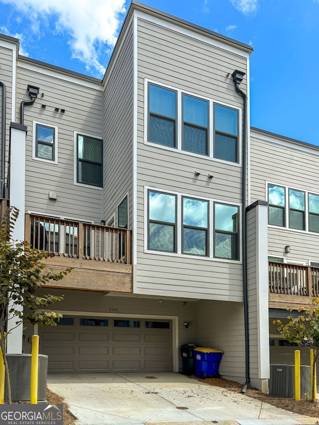 rear view of house featuring a balcony and a garage