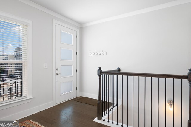 foyer with ornamental molding and dark hardwood / wood-style floors