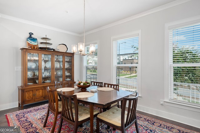 dining room with a notable chandelier, ornamental molding, and dark hardwood / wood-style flooring