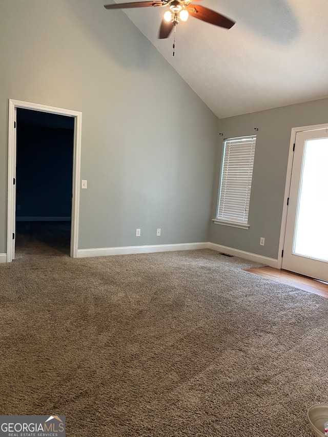 carpeted empty room featuring high vaulted ceiling and ceiling fan