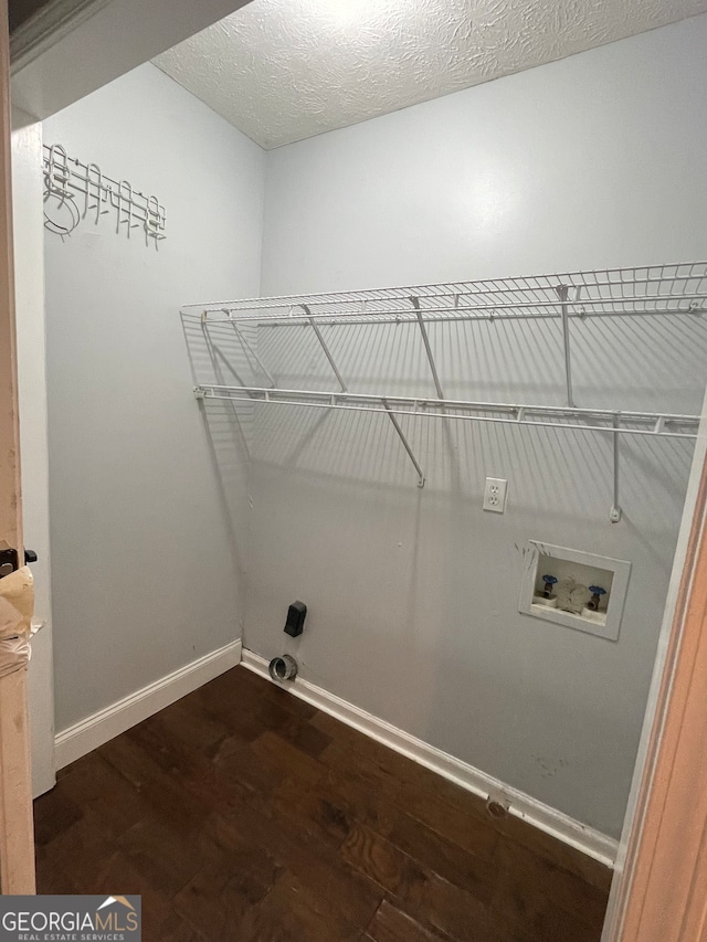 washroom featuring a textured ceiling, dark hardwood / wood-style floors, and washer hookup