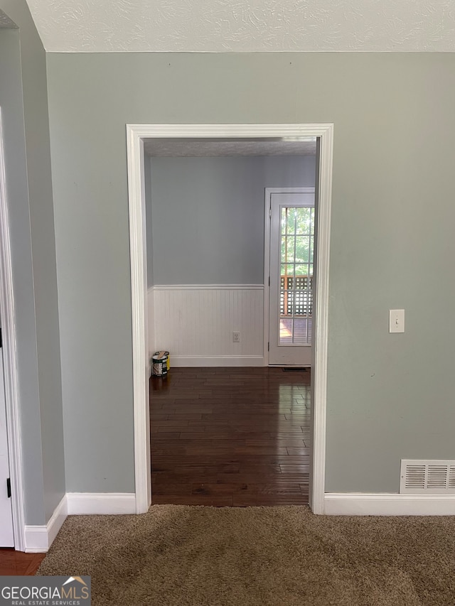 interior space with a textured ceiling and dark wood-type flooring