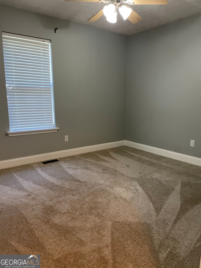 unfurnished room featuring ceiling fan and carpet floors