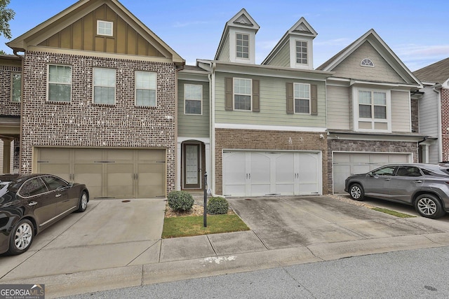 townhome / multi-family property featuring brick siding, a garage, driveway, and board and batten siding