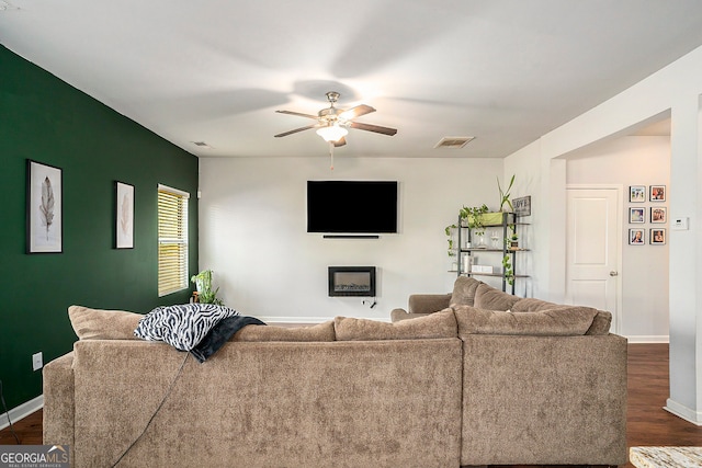 living room with dark hardwood / wood-style flooring and ceiling fan