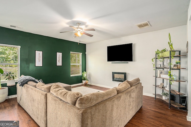 living room with ceiling fan and dark wood-type flooring