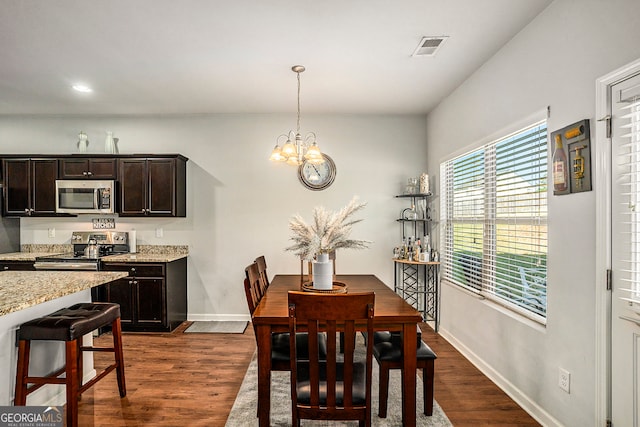 dining space featuring a notable chandelier and dark wood-type flooring