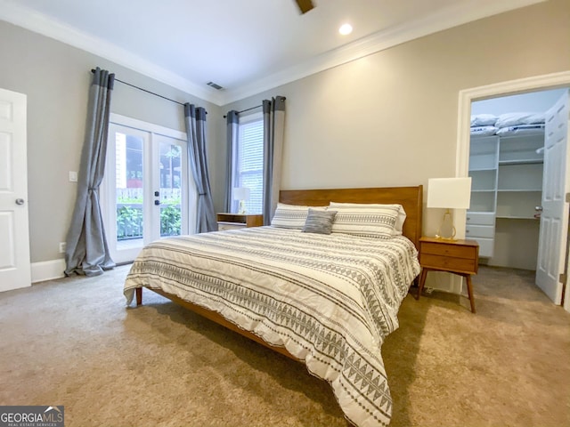 carpeted bedroom featuring a walk in closet, a closet, french doors, access to outside, and ornamental molding