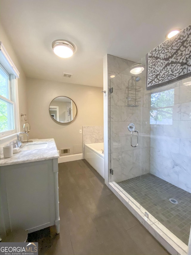 bathroom featuring shower with separate bathtub and vanity