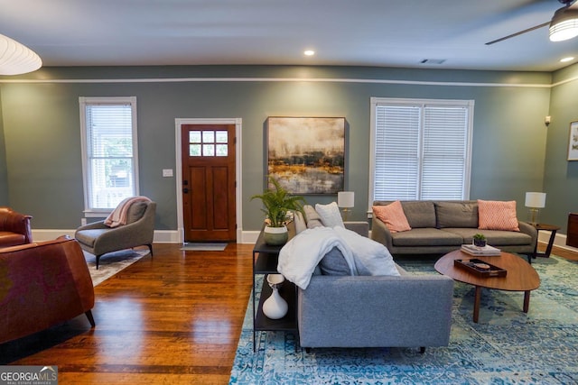 living room with dark hardwood / wood-style flooring and ceiling fan