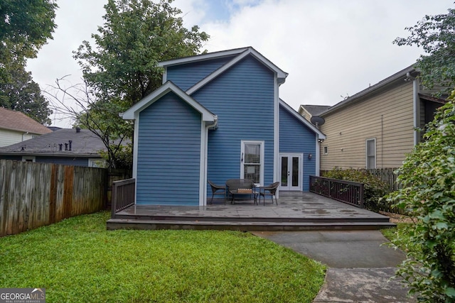 back of house with a wooden deck and a yard