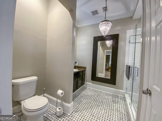 bathroom with an inviting chandelier, vanity, toilet, and a shower with shower door