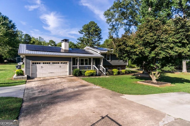 view of front of property featuring a garage, covered porch, a front lawn, and solar panels