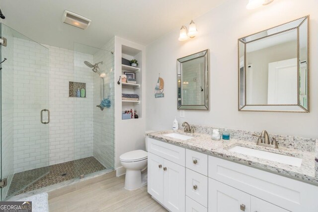 bathroom featuring an enclosed shower, toilet, and vanity