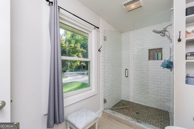 bathroom featuring hardwood / wood-style flooring and a shower with shower door