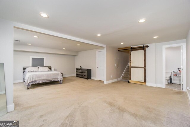 carpeted bedroom featuring a barn door