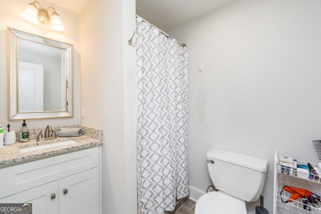 bathroom with a shower with shower curtain, toilet, and vanity