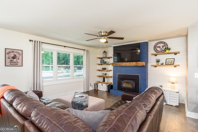 living room with a fireplace, dark hardwood / wood-style flooring, and ceiling fan