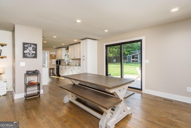 dining room featuring dark wood-type flooring and sink