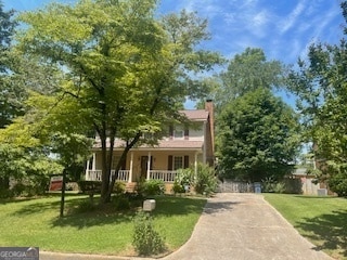 view of front of house with covered porch and a front lawn