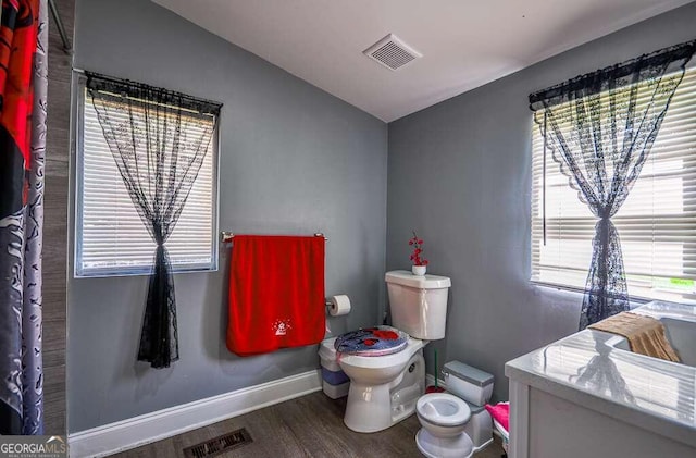 bathroom featuring toilet and wood-type flooring